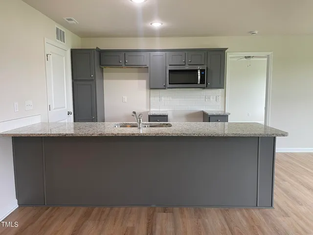 a kitchen with granite countertop a sink and cabinets