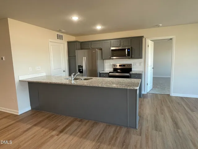 a kitchen with stainless steel appliances granite countertop a sink and cabinets