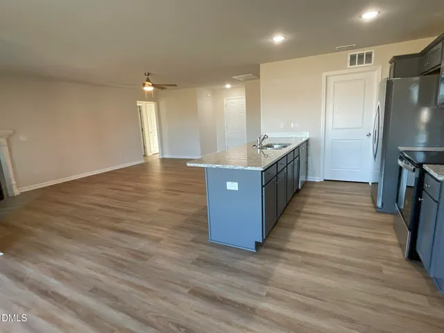 a large kitchen with stainless steel appliances a large counter top and a stove