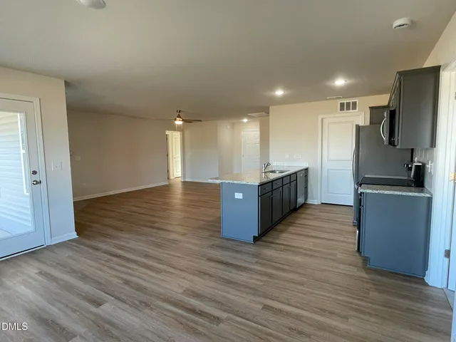 a kitchen with stainless steel appliances kitchen island granite countertop a large counter top and a refrigerator