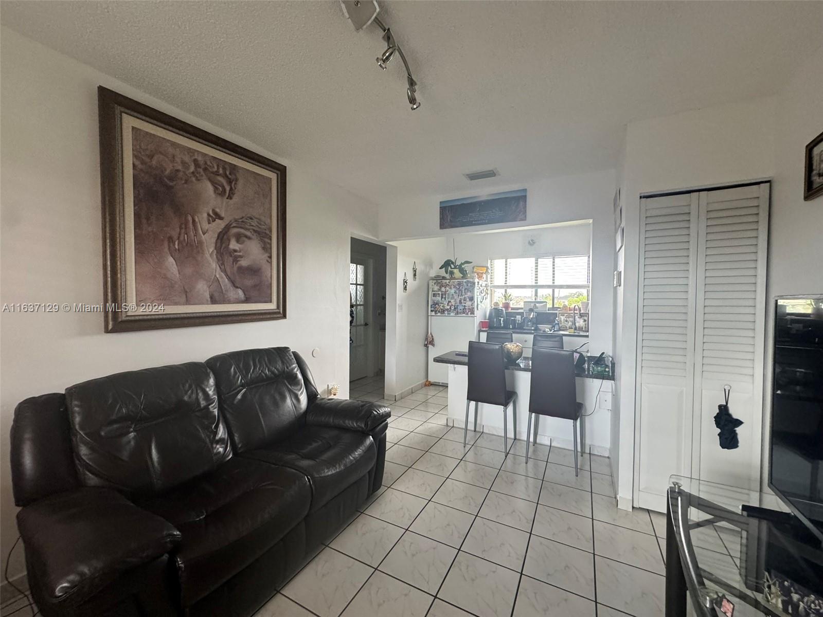 231 East 7th Street Hialeah, FL 33010 - Photo 14 of 39 a living room with furniture a flat screen tv and a large window