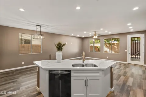 a kitchen with kitchen island a sink appliances and a large window