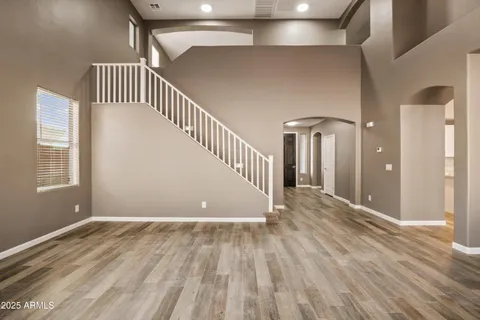 a view of a hallway with wooden floor and staircase