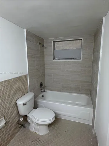 a bathroom with a toilet and a bath tub