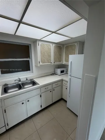 a kitchen with sink cabinets and microwave