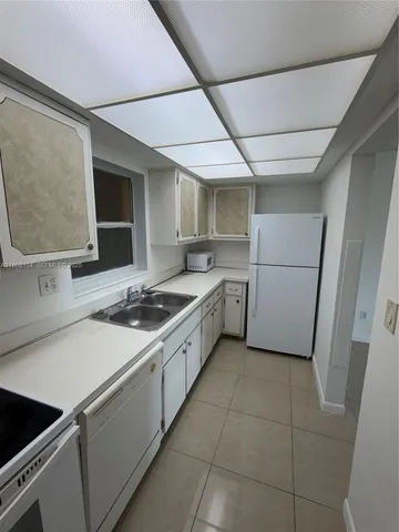 a kitchen with a sink appliances and cabinets