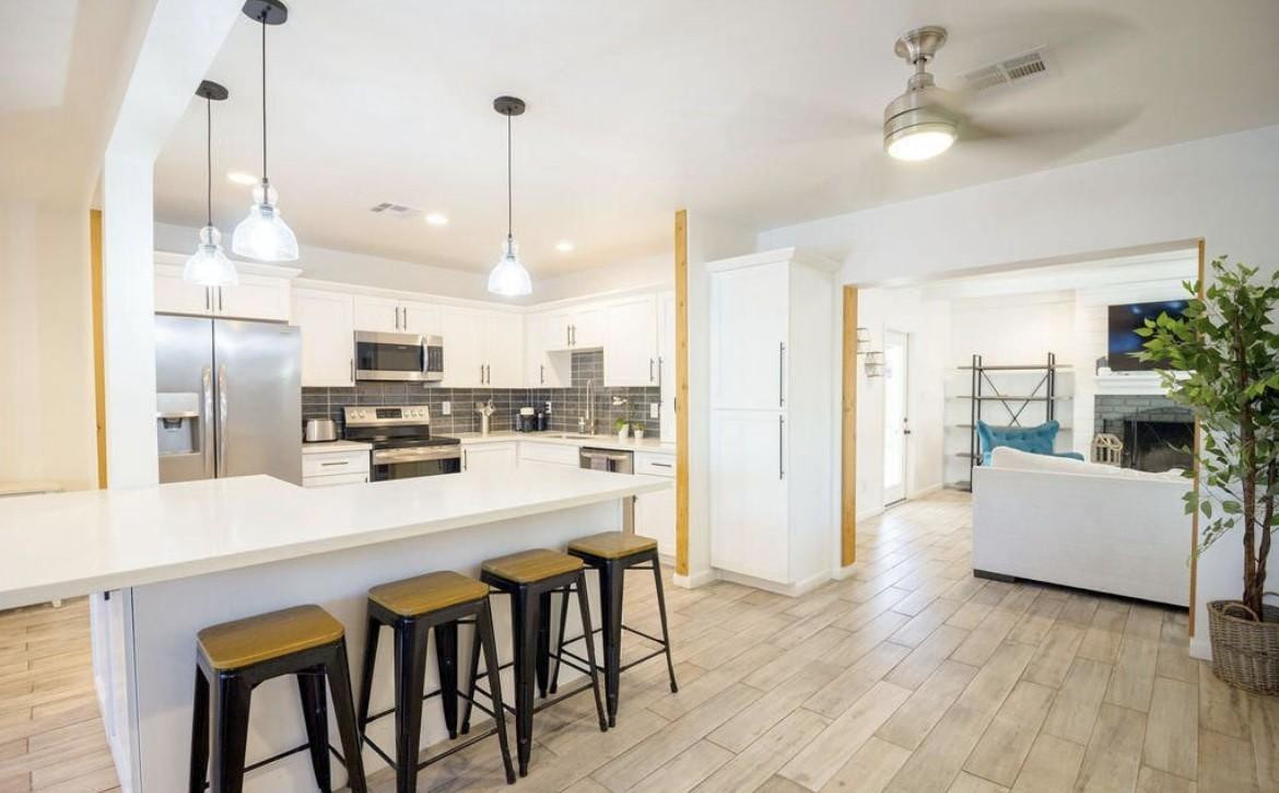 4214 North 20th Street Phoenix, AZ 85016 - Photo 11 of 40 a kitchen with stainless steel appliances a dining table chairs refrigerator and microwave