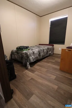 a bedroom with a bed and a flat tv screen on the dresser