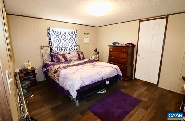 a bedroom with a bed and a mirror on the wall