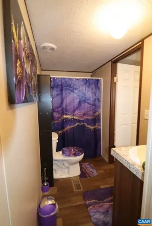 a bathroom with a toilet and a shower curtain