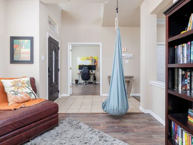 a living room with furniture a bookshelf and a window