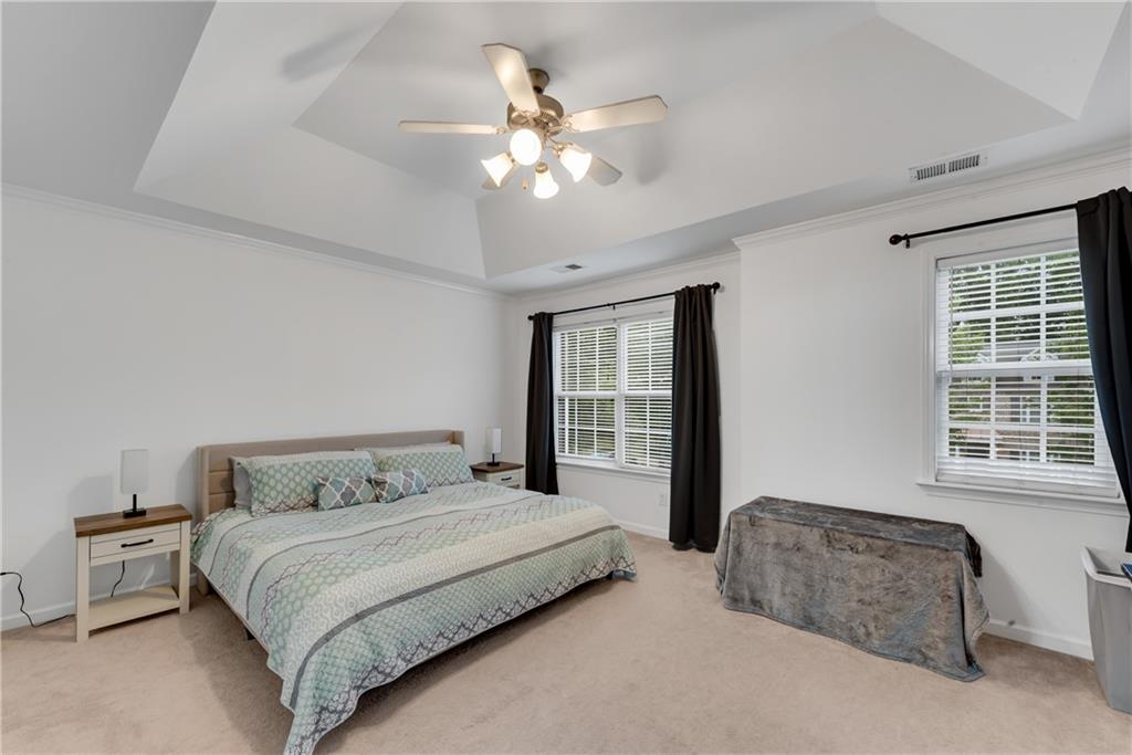 1791 Heights Circle Kennesaw, GA 30152 - Photo 13 of 24 a bedroom with a large bed and a chandelier