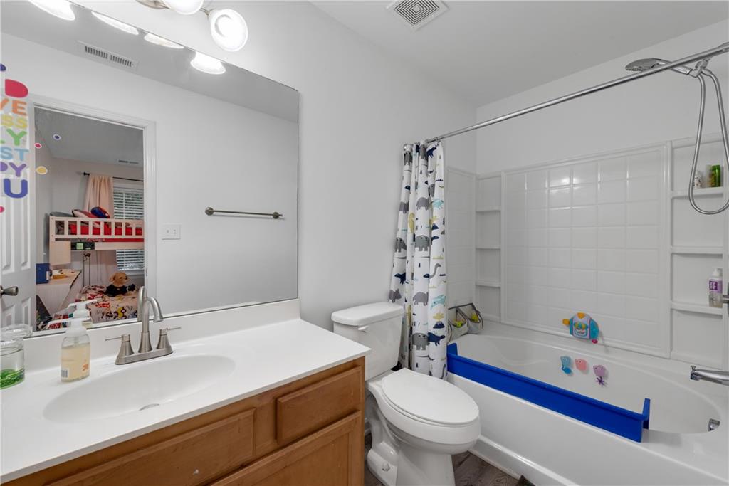1791 Heights Circle Kennesaw, GA 30152 - Photo 22 of 24 a bathroom with a sink a toilet and a mirror