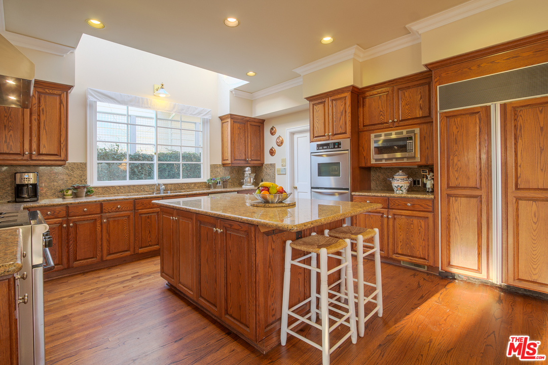 340 11th Street Santa Monica, CA 90402 - Photo 11 of 28 a open kitchen with stainless steel appliances granite countertop a stove a sink dishwasher and a refrigerator with wooden floor
