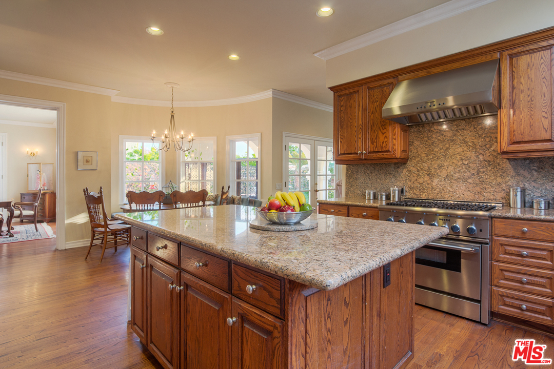 340 11th Street Santa Monica, CA 90402 - Photo 12 of 28 a kitchen with stainless steel appliances granite countertop a sink a stove and a wooden floors