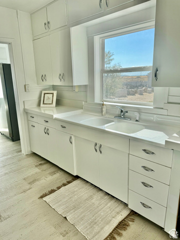 4375 West 4500 S Road Deseret, UT 84624 - Photo 7 of 20 White cabinetry with chrome hardware, an integrated double basin sink, and wood-finish flooring