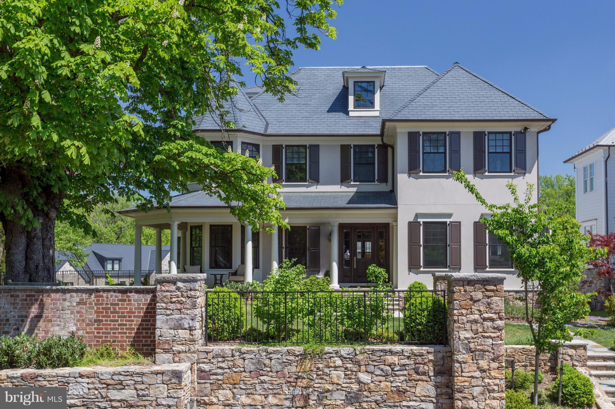 a view of a white house with large windows and a small yard