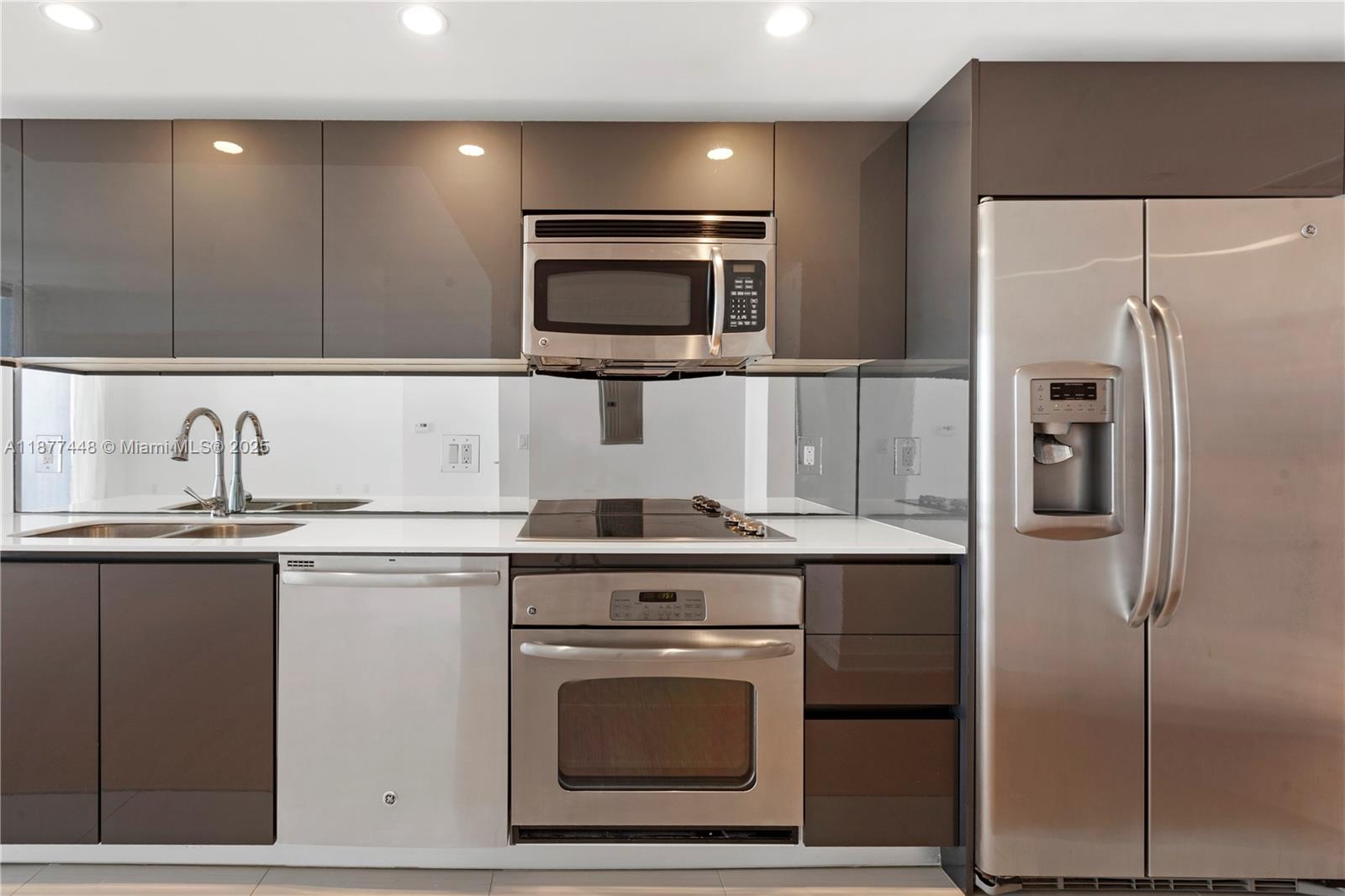 31 Southeast 6th Street, Unit 705 Miami, FL 33131 - Photo 8 of 12 a kitchen with cabinets stainless steel appliances and a sink