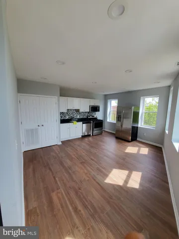 a view of empty room with a kitchen and window