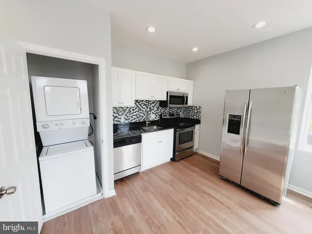 a kitchen with stainless steel appliances a refrigerator and a stove top oven
