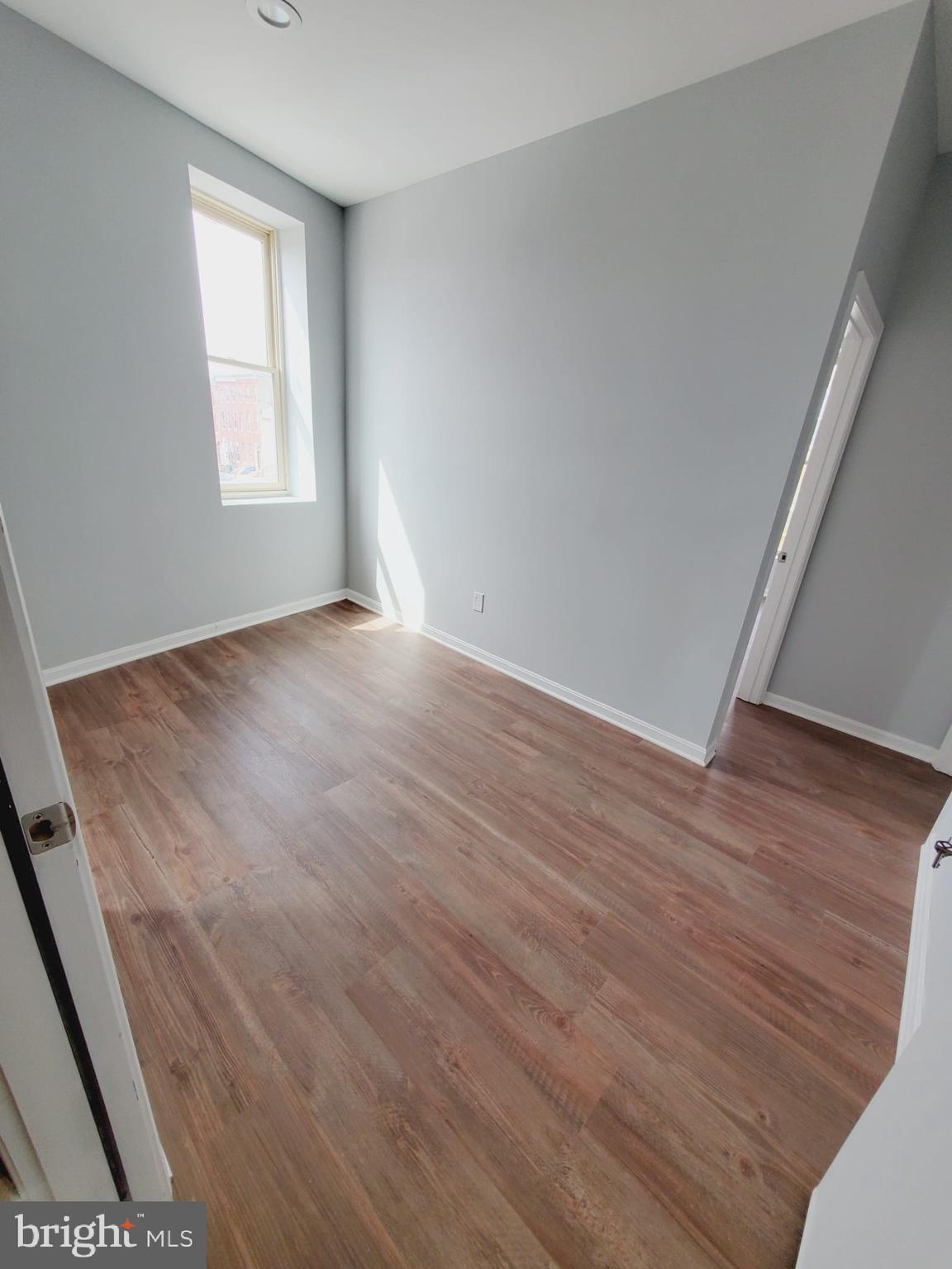 27 South Fulton Avenue Baltimore, MD 21223 - Photo 20 of 20 an empty room with wooden floor and windows