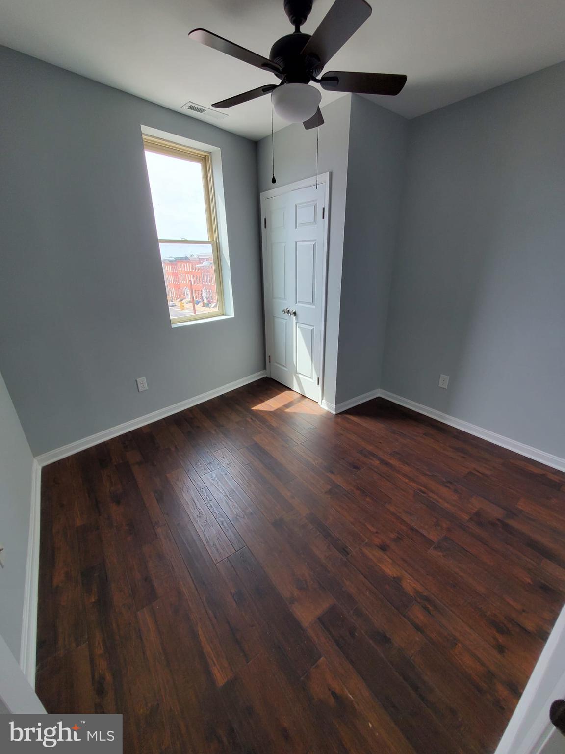 27 South Fulton Avenue Baltimore, MD 21223 - Photo 7 of 20 a view of an empty room with wooden floor and a window