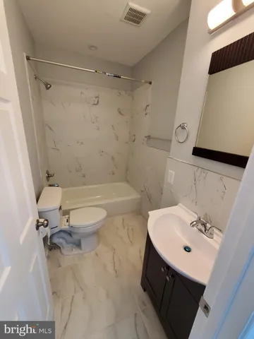 a bathroom with a sink mirror bathtub and toilet