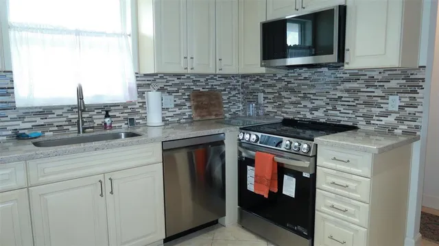a kitchen with stainless steel appliances granite countertop a stove microwave and cabinets