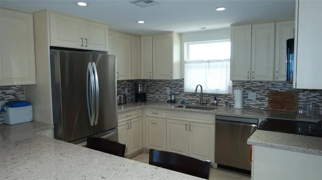 a kitchen with a refrigerator sink and cabinets