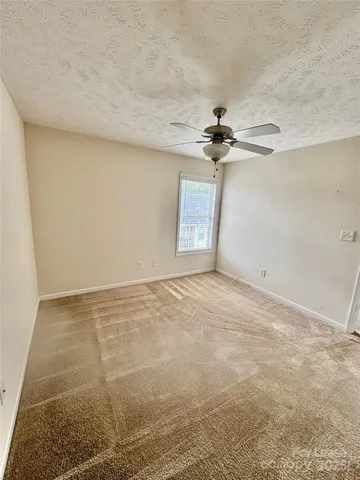 an empty room with a ceiling fan and a window