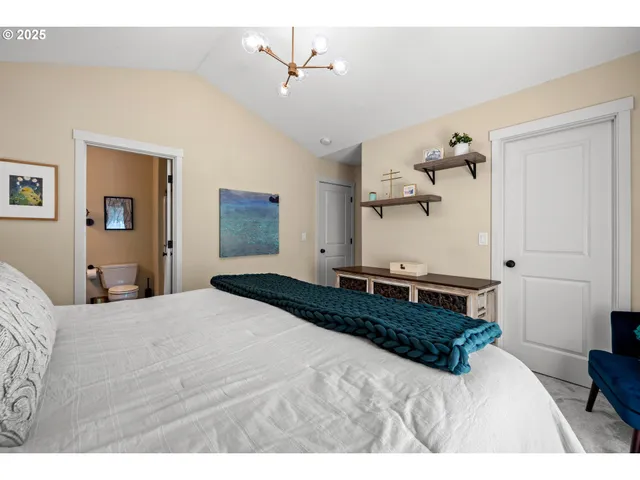 a bedroom with a large bed and a chandelier