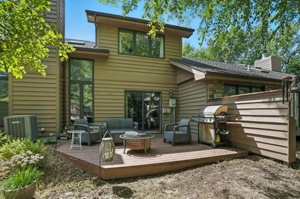 a view of a chair and table in the back yard of the house