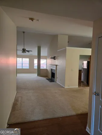 a big room with chandelier fan and windows