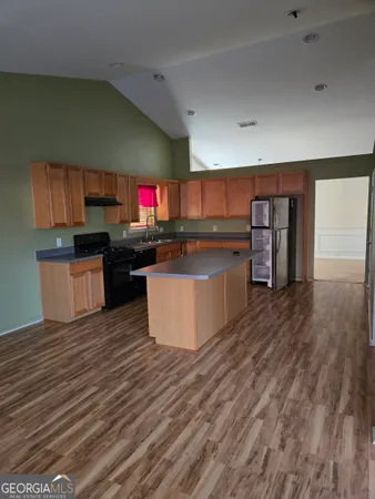 a kitchen with stainless steel appliances wooden floors and wooden cabinets