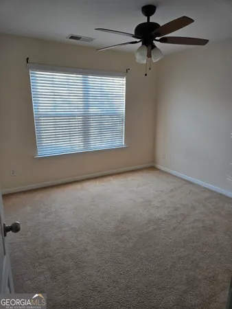 a view of a livingroom with a ceiling fan and window