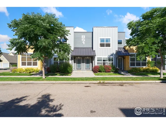 a house view with a garden and tall trees