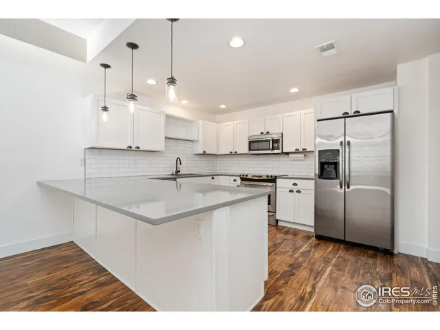 a kitchen with kitchen island a sink stainless steel appliances and cabinets