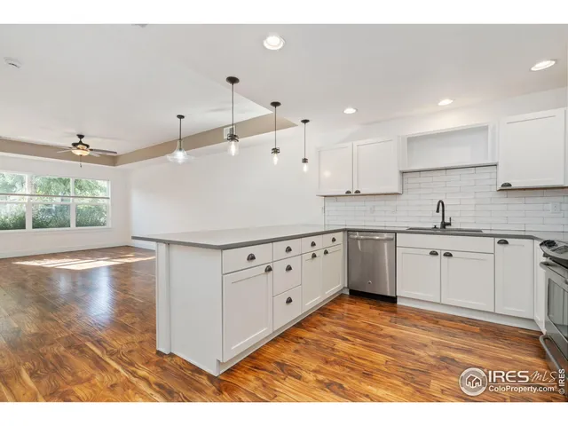 a kitchen with granite countertop a white stove top oven sink and cabinets