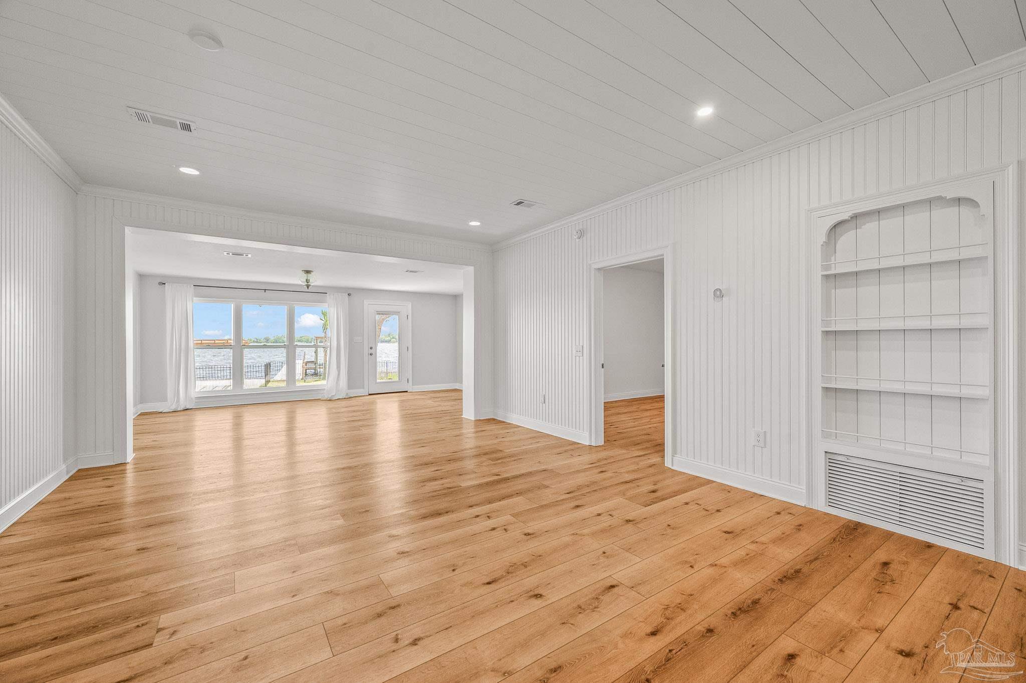 7693 Petersen Point Road Milton, FL 32583 - Photo 12 of 58 a view of an empty room with a window and wooden floor