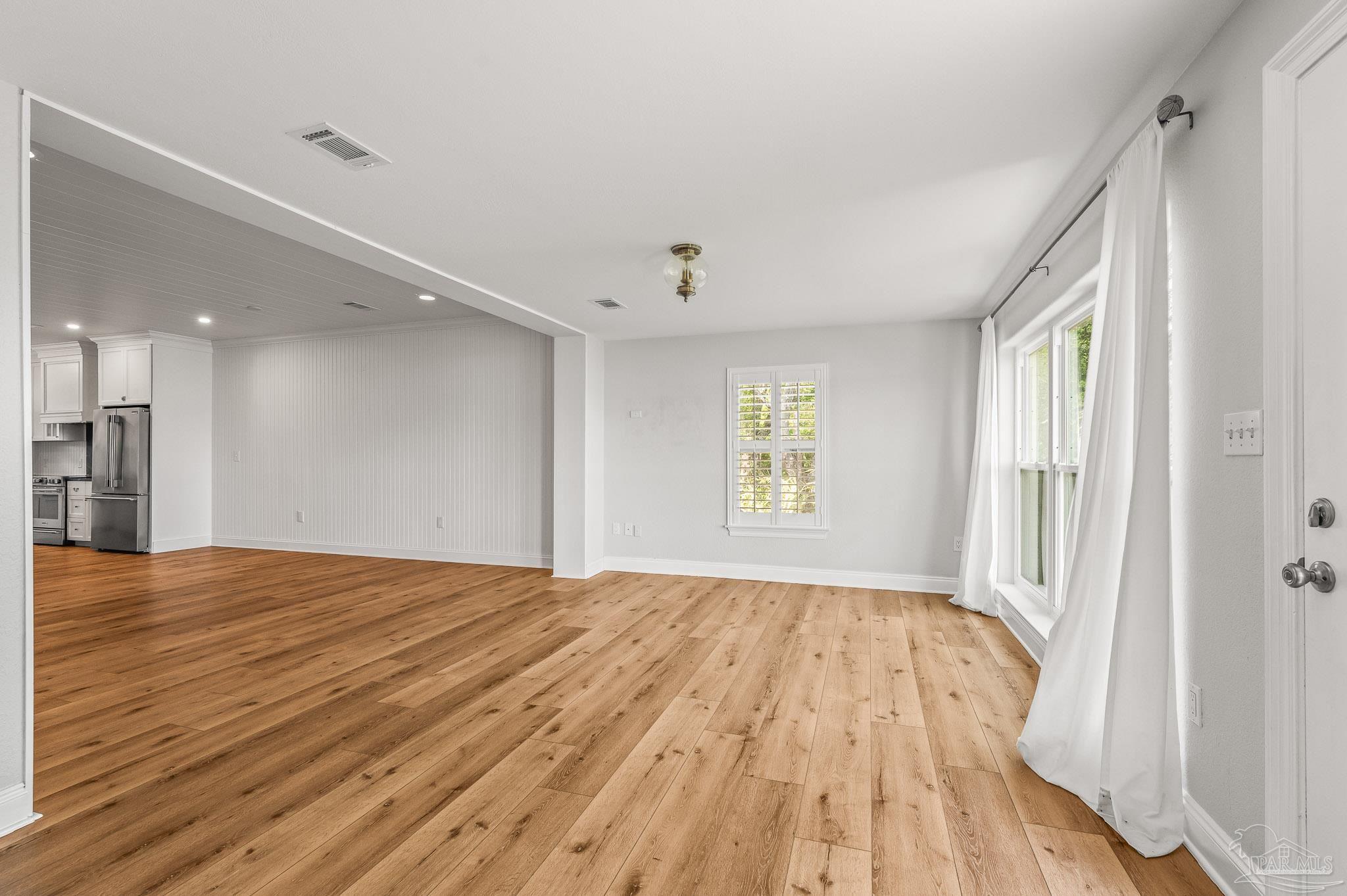 7693 Petersen Point Road Milton, FL 32583 - Photo 17 of 58 a view of an empty room with wooden floor and a window