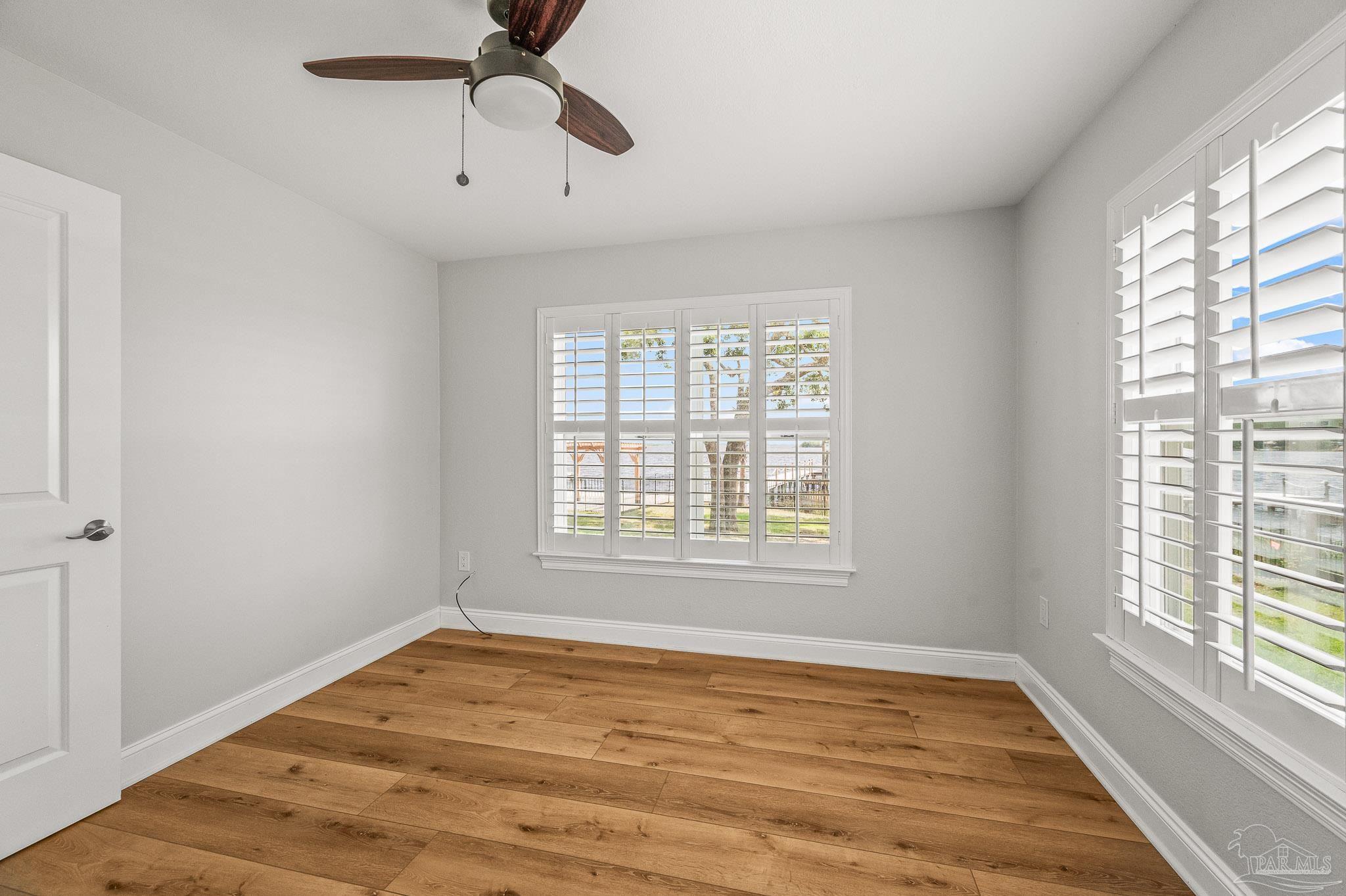 7693 Petersen Point Road Milton, FL 32583 - Photo 18 of 58 a view of an empty room with a window and wooden floor