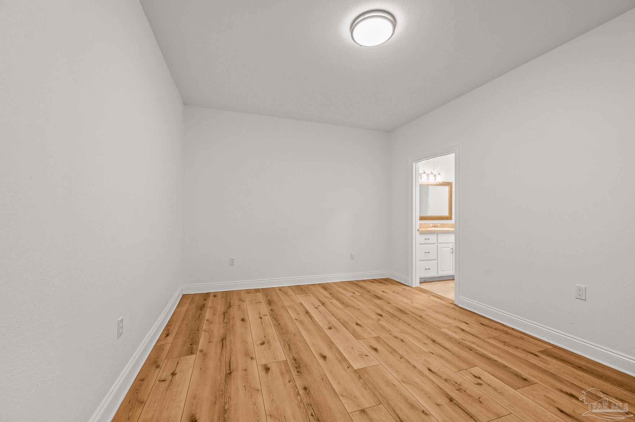 7693 Petersen Point Road Milton, FL 32583 - Photo 20 of 58 a view of a room with wooden floor and white walls