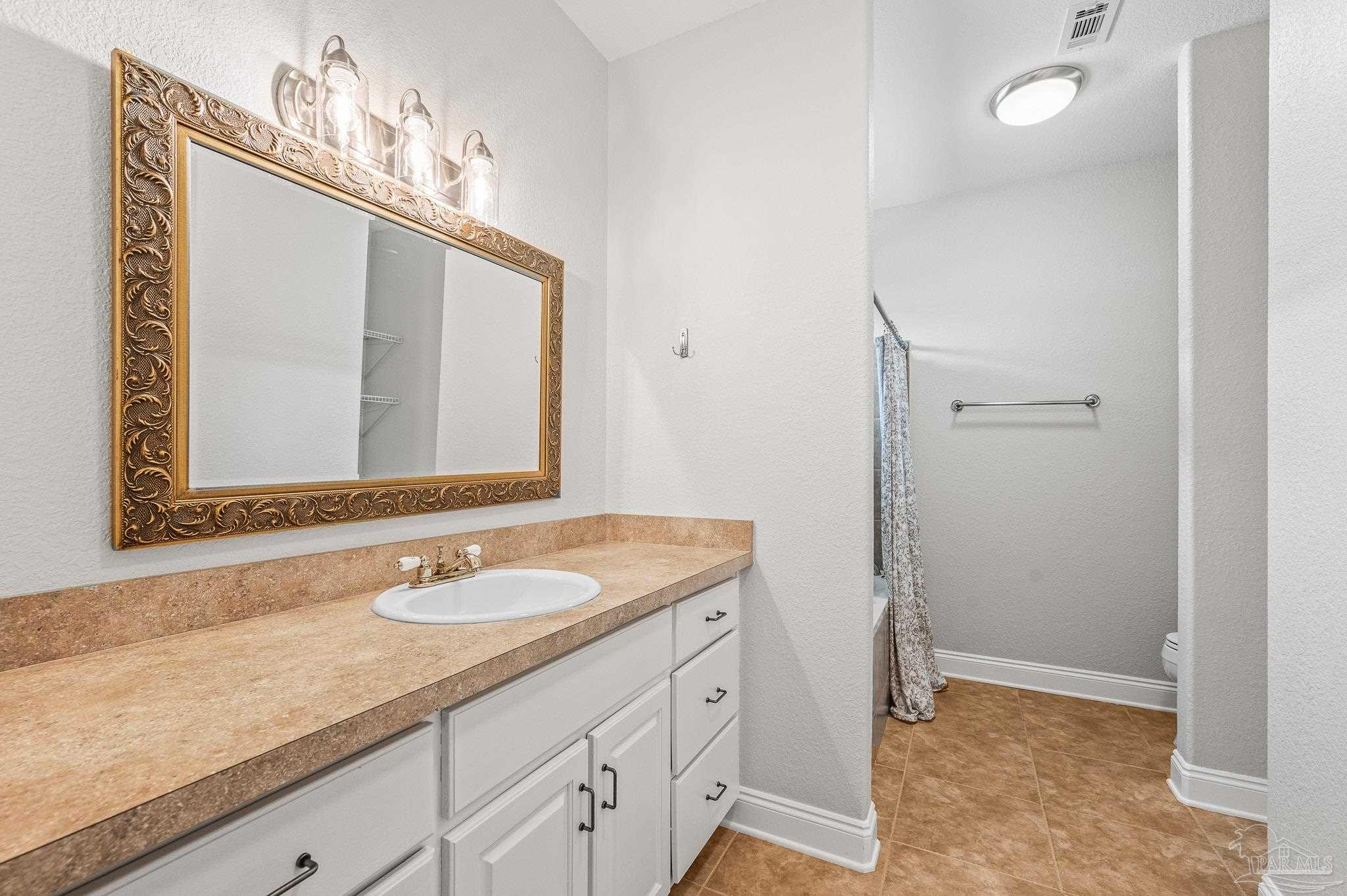 7693 Petersen Point Road Milton, FL 32583 - Photo 21 of 58 a bathroom with a granite countertop sink and a mirror