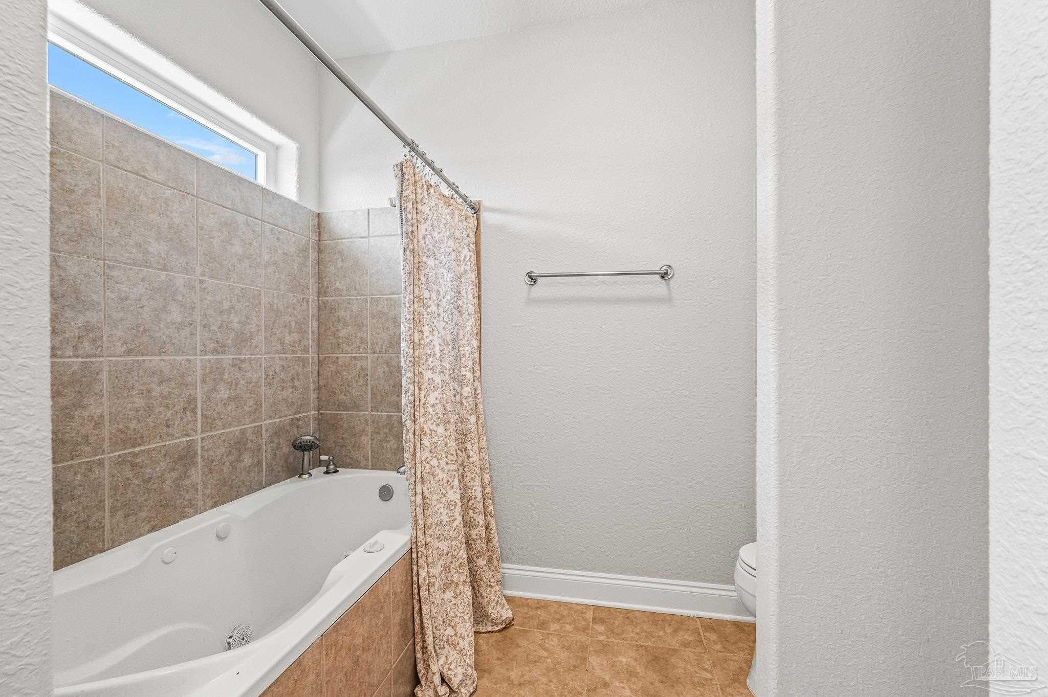 7693 Petersen Point Road Milton, FL 32583 - Photo 23 of 58 a bathroom with a bathtub and a shower