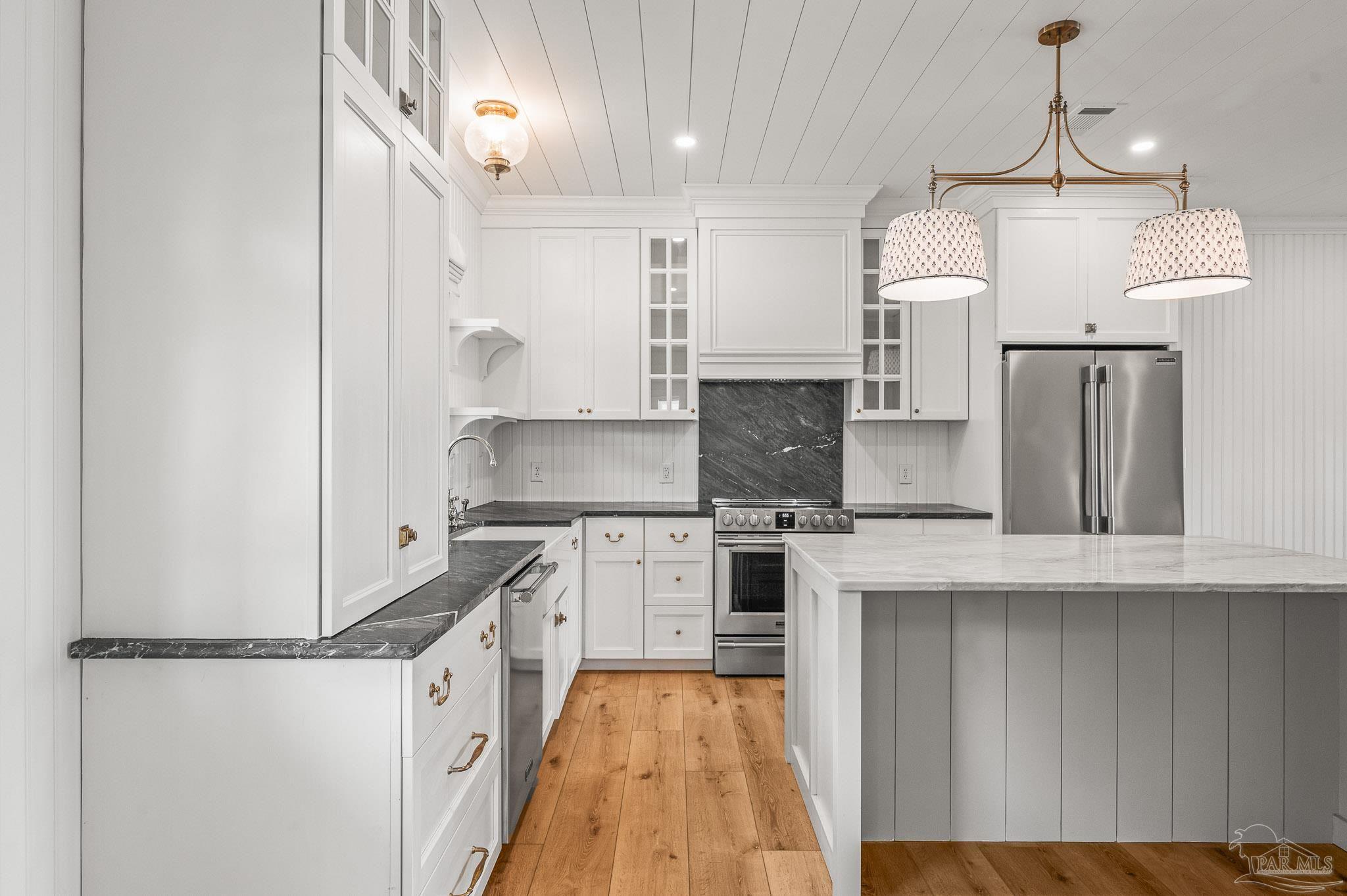 7693 Petersen Point Road Milton, FL 32583 - Photo 27 of 58 a kitchen with stainless steel appliances granite countertop a sink stove and refrigerator