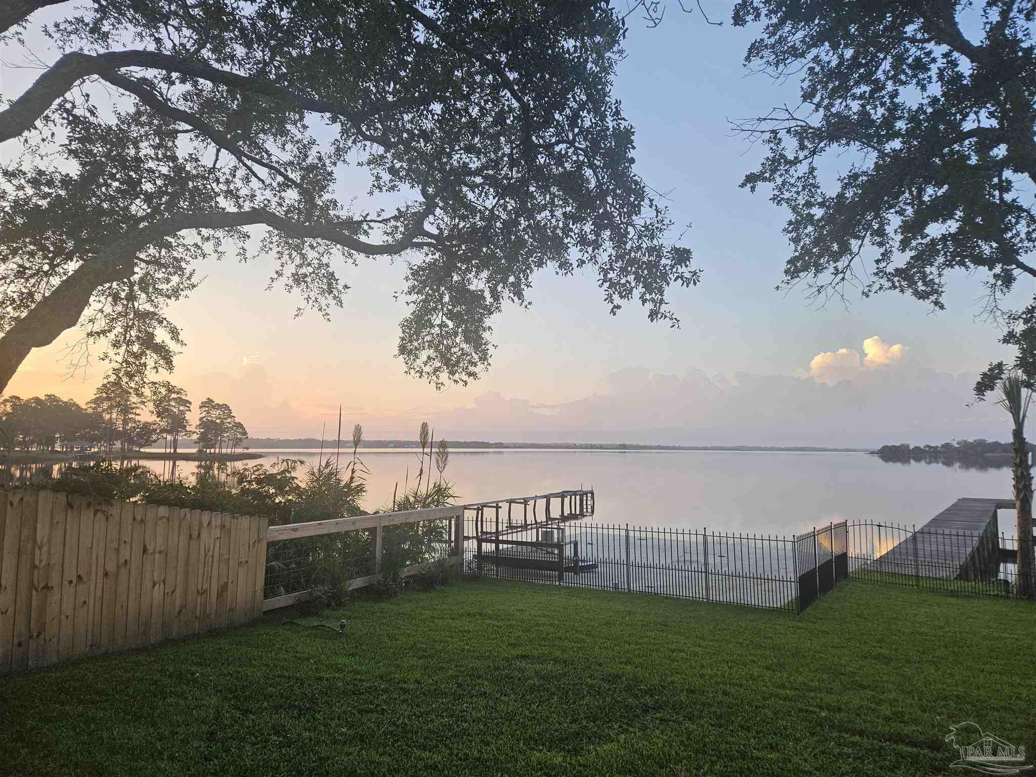 7693 Petersen Point Road Milton, FL 32583 - Photo 30 of 58 a view of a lake with a yard
