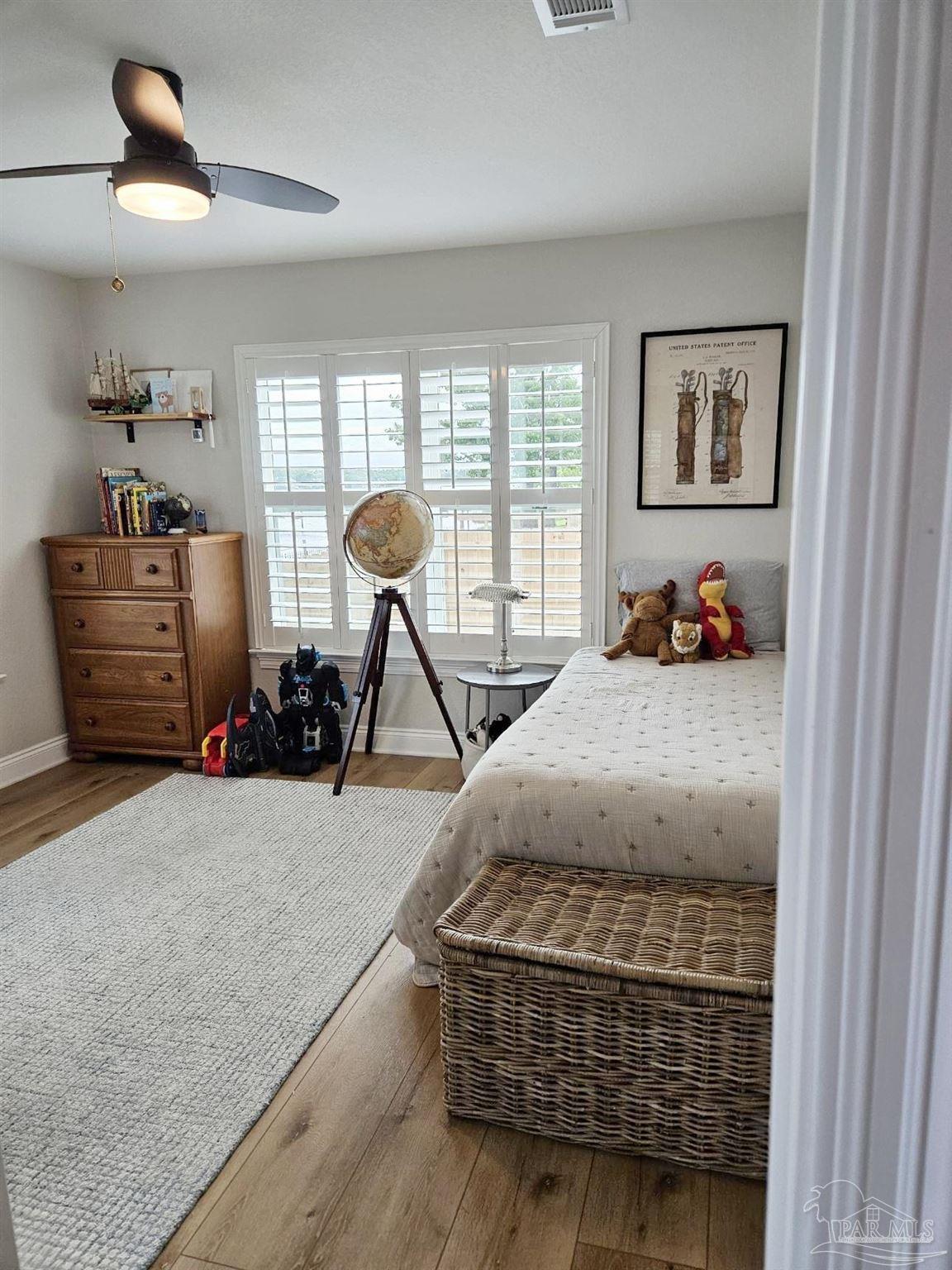 7693 Petersen Point Road Milton, FL 32583 - Photo 36 of 58 a bedroom with furniture and a wooden floor