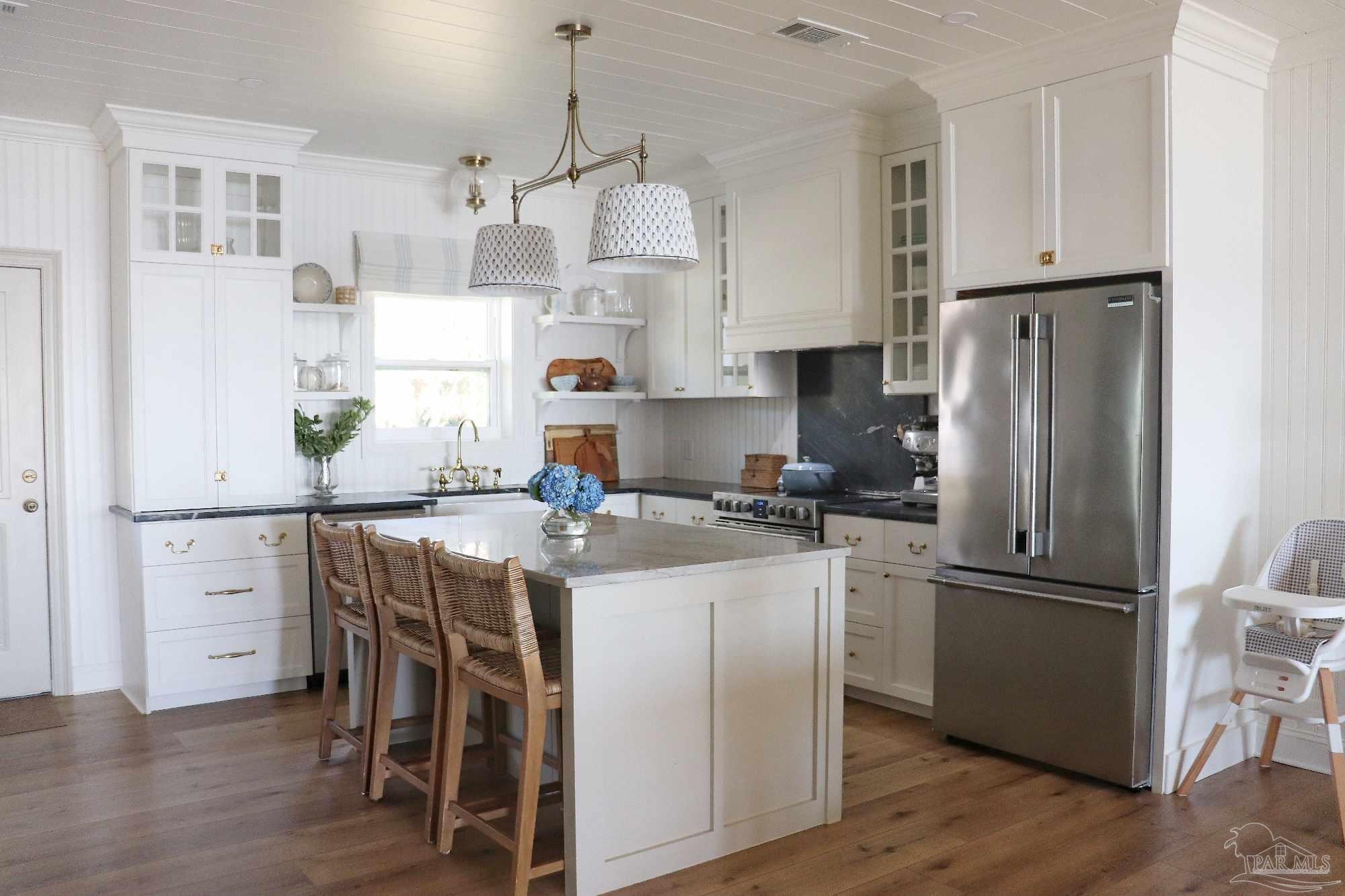 7693 Petersen Point Road Milton, FL 32583 - Photo 37 of 58 a kitchen with stainless steel appliances a refrigerator a stove a sink dishwasher and a refrigerator with wooden floor