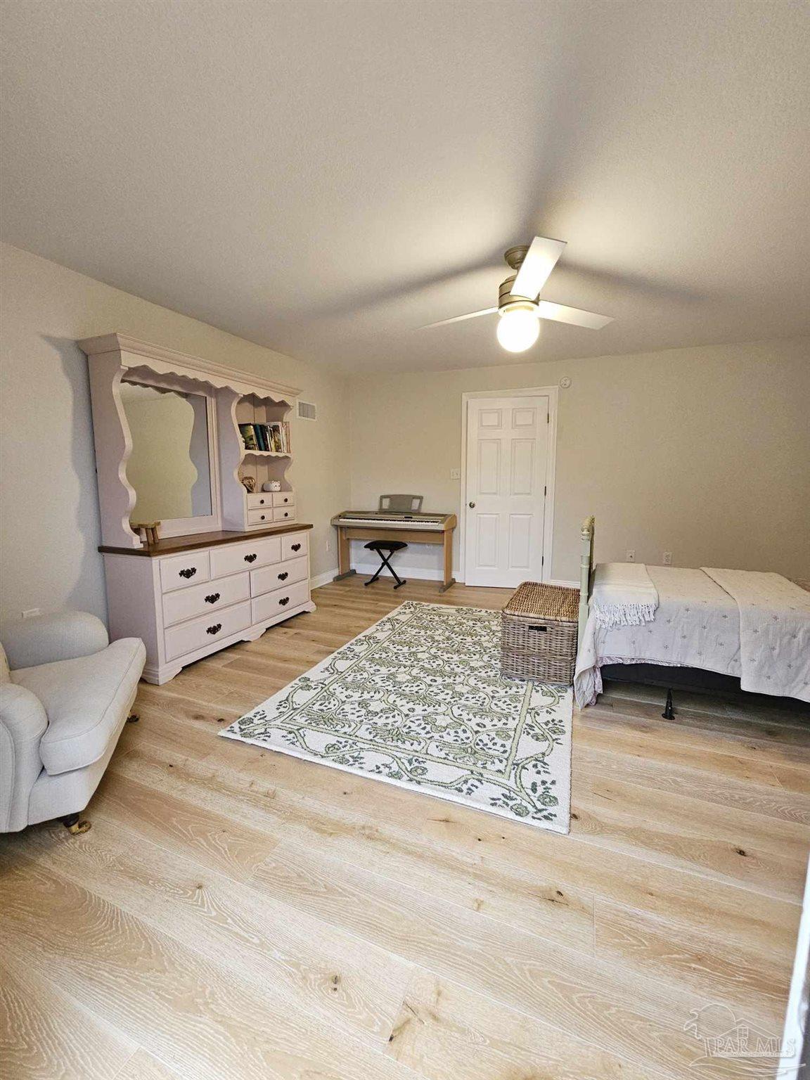 7693 Petersen Point Road Milton, FL 32583 - Photo 41 of 58 a bedroom with a bed and a chandelier