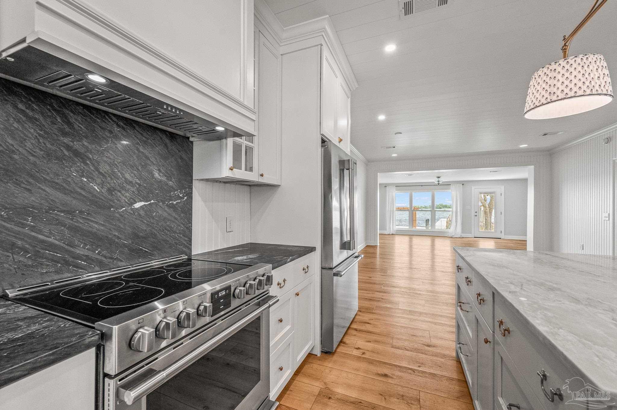 7693 Petersen Point Road Milton, FL 32583 - Photo 7 of 58 a kitchen with a stove and a wooden floor